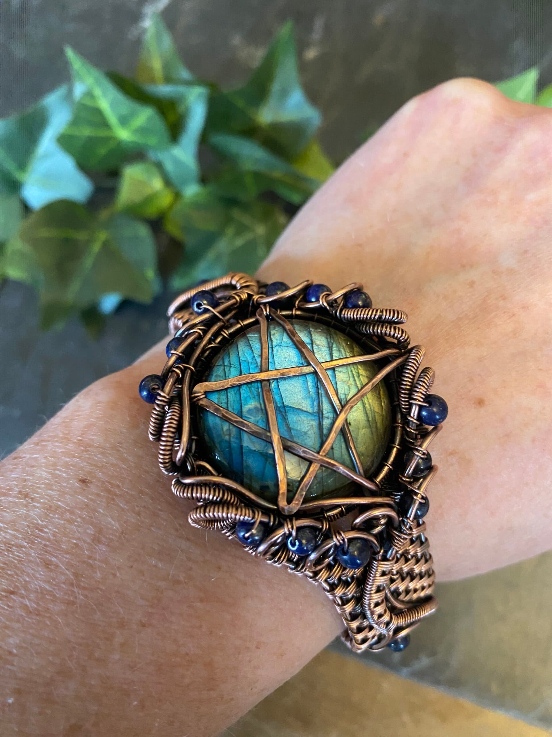 Handwoven copper pentagram cuff bracelet with hammered symbol and lapis lazuli beads Copper pentagram cuff bracelet showing woven wire detail and blue beads Handwoven copper cuff bracelet with antiqued pentagram and lapis accents
