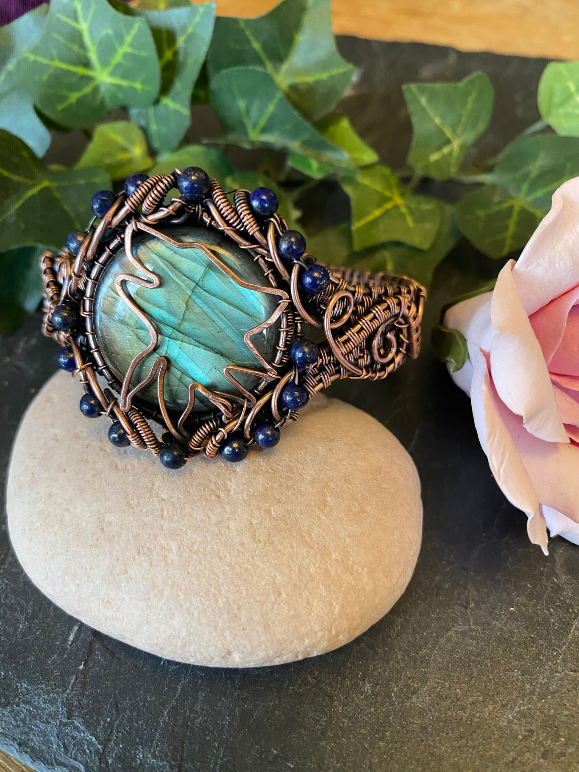 Handwoven copper wolf head cuff bracelet with labradorite and lapis lazuli beads Copper wolf head cuff showing woven wire detail and gemstone centerpiece Handwoven copper cuff bracelet with hammered wolf symbol and mystical stones