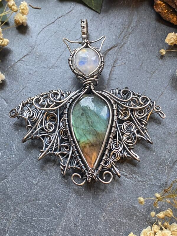 Handmade labradorite bat pendant with green, gold and brown flash gemstone body, Rainbow Moonstone head and ornate silver filled wire woven wings.