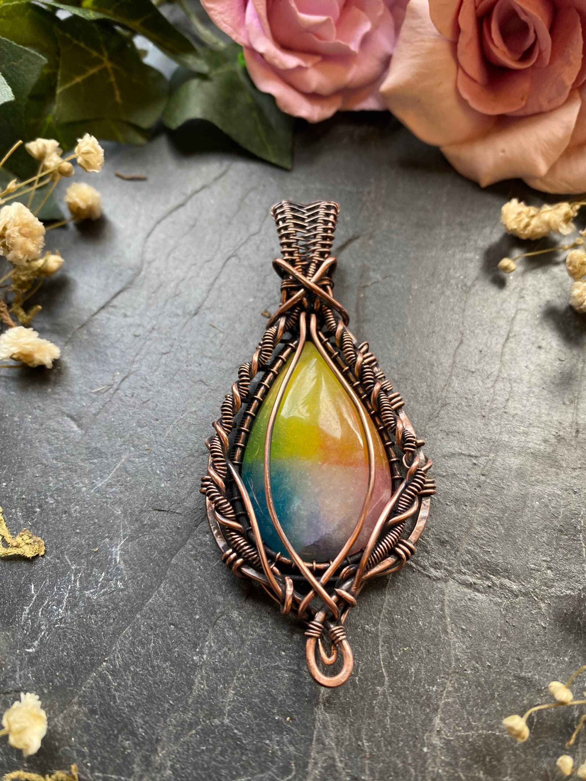 Handmade rainbow agate pendant featuring genuine dyed teardrop agate with yellow, green, blue and purple colours, wrapped in detailed copper wire.