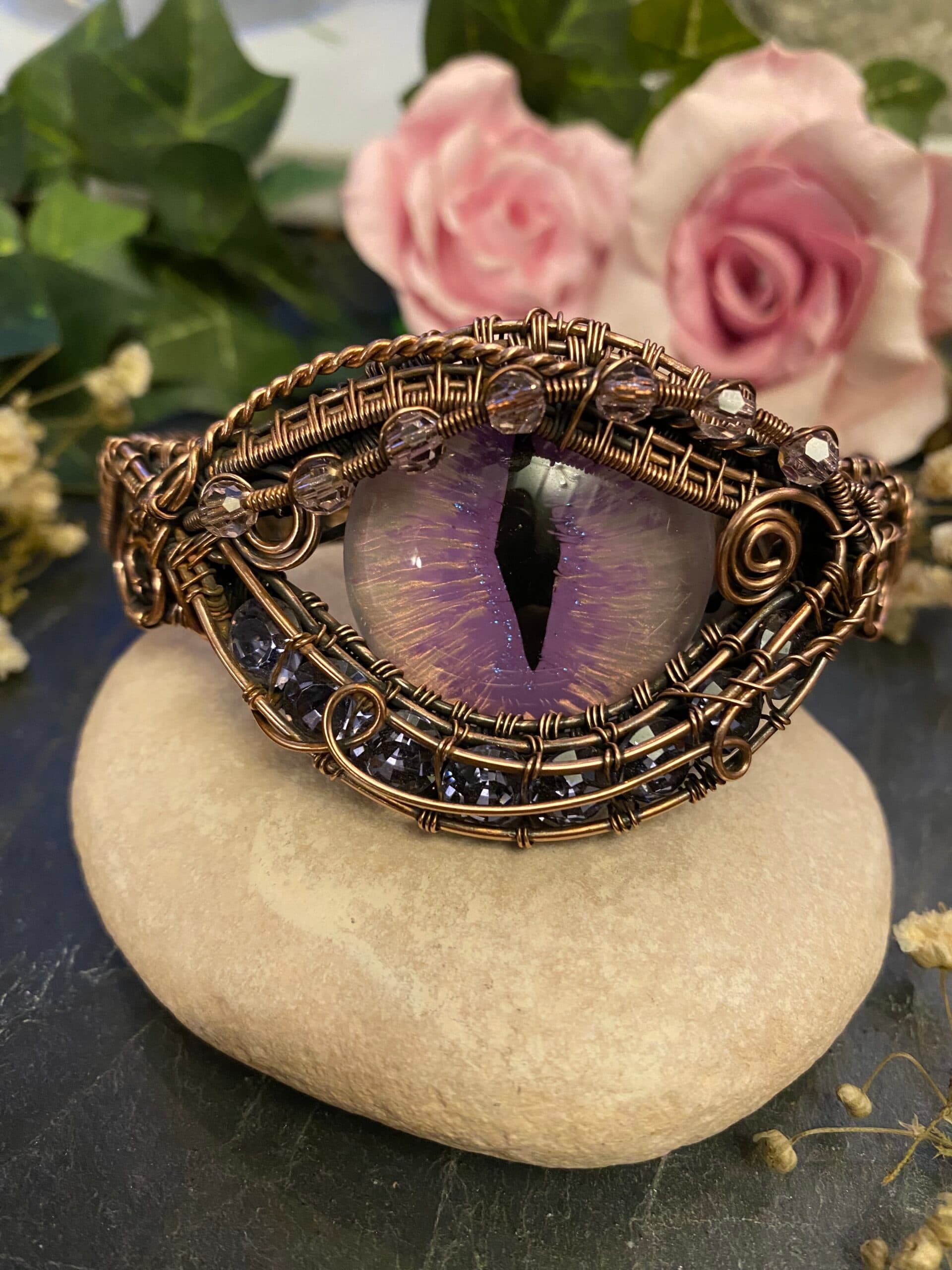 Handmade purple dragon eye cuff bracelet in woven copper wire with lilac painted eye, purple Swarovski crystals and glass rondelle beads.