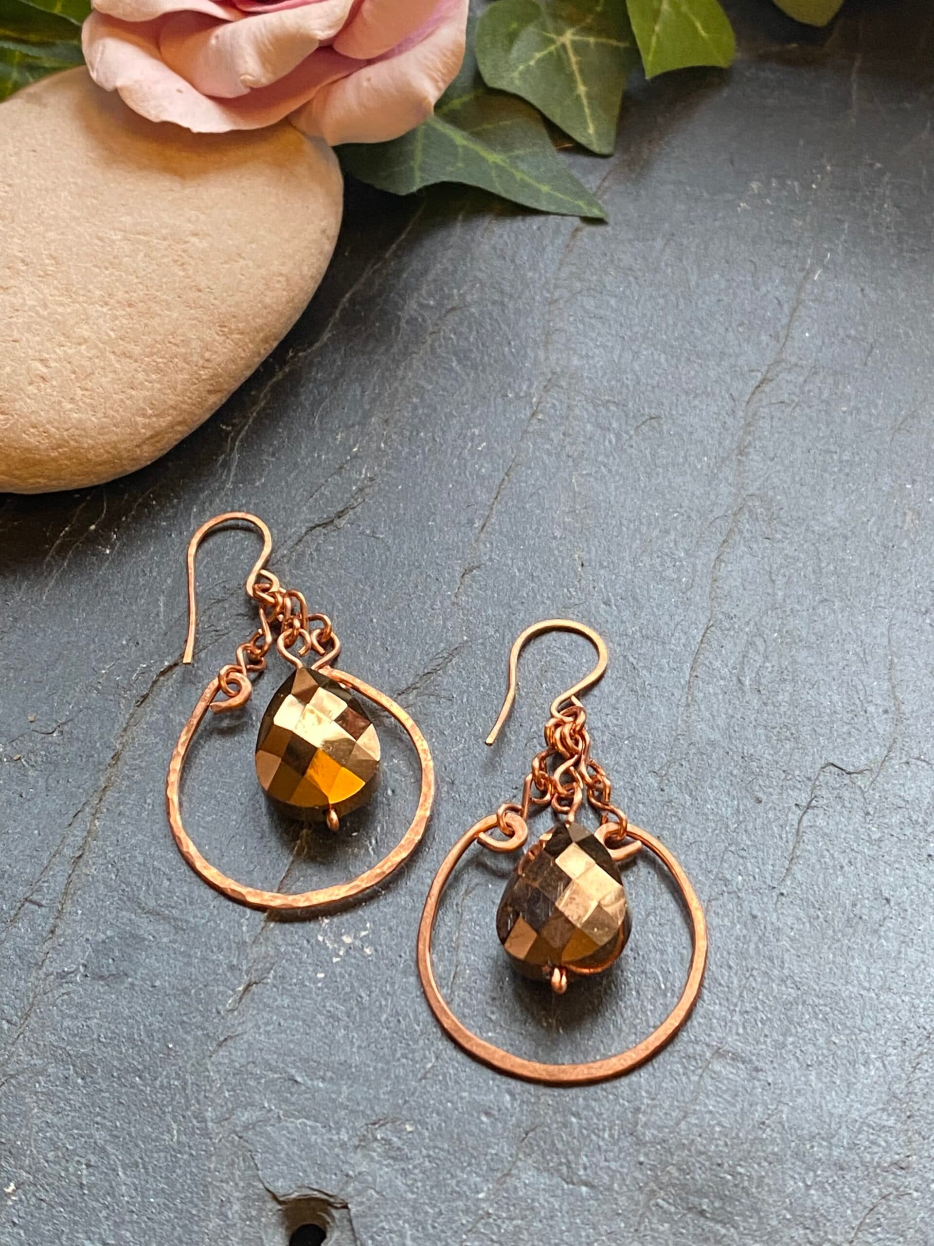 Handmade copper dangle earrings with hammered loop components and a teardrop shaped copper metallic glass bead.