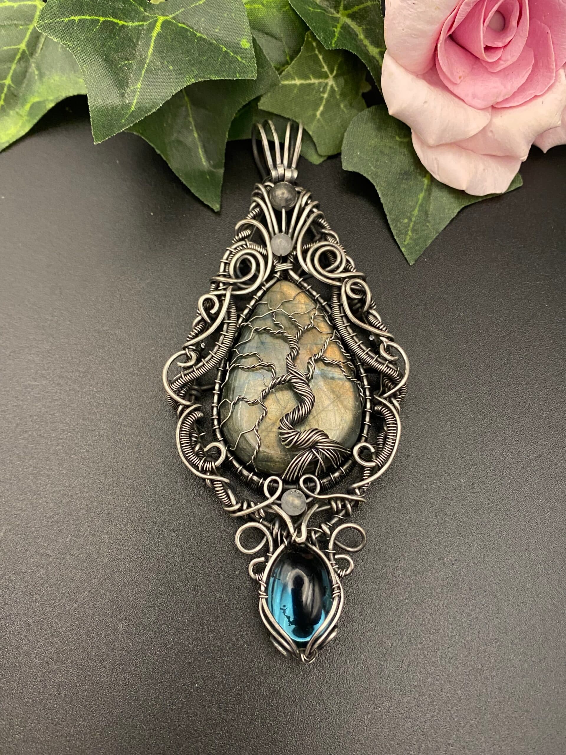 Large teardrop labradorite Tree of Life pendant on a measuring mat showing detailed silver wire weaving and a hanging Preciosa glass cabochon.