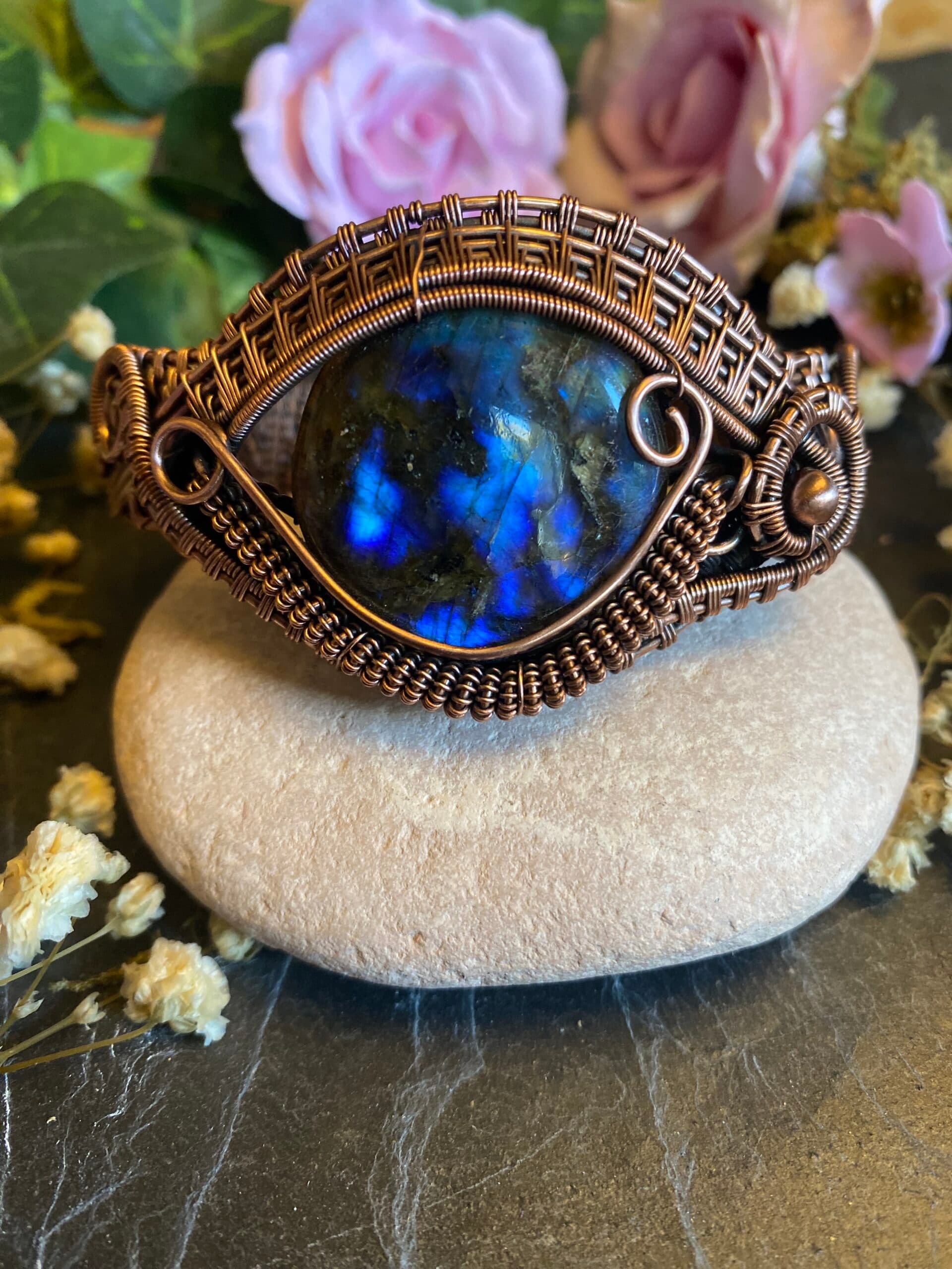 Front view of handmade labradorite eye cuff bracelet with brilliant blue flash gemstone, antiqued copper weaving and decorative scrollwork.