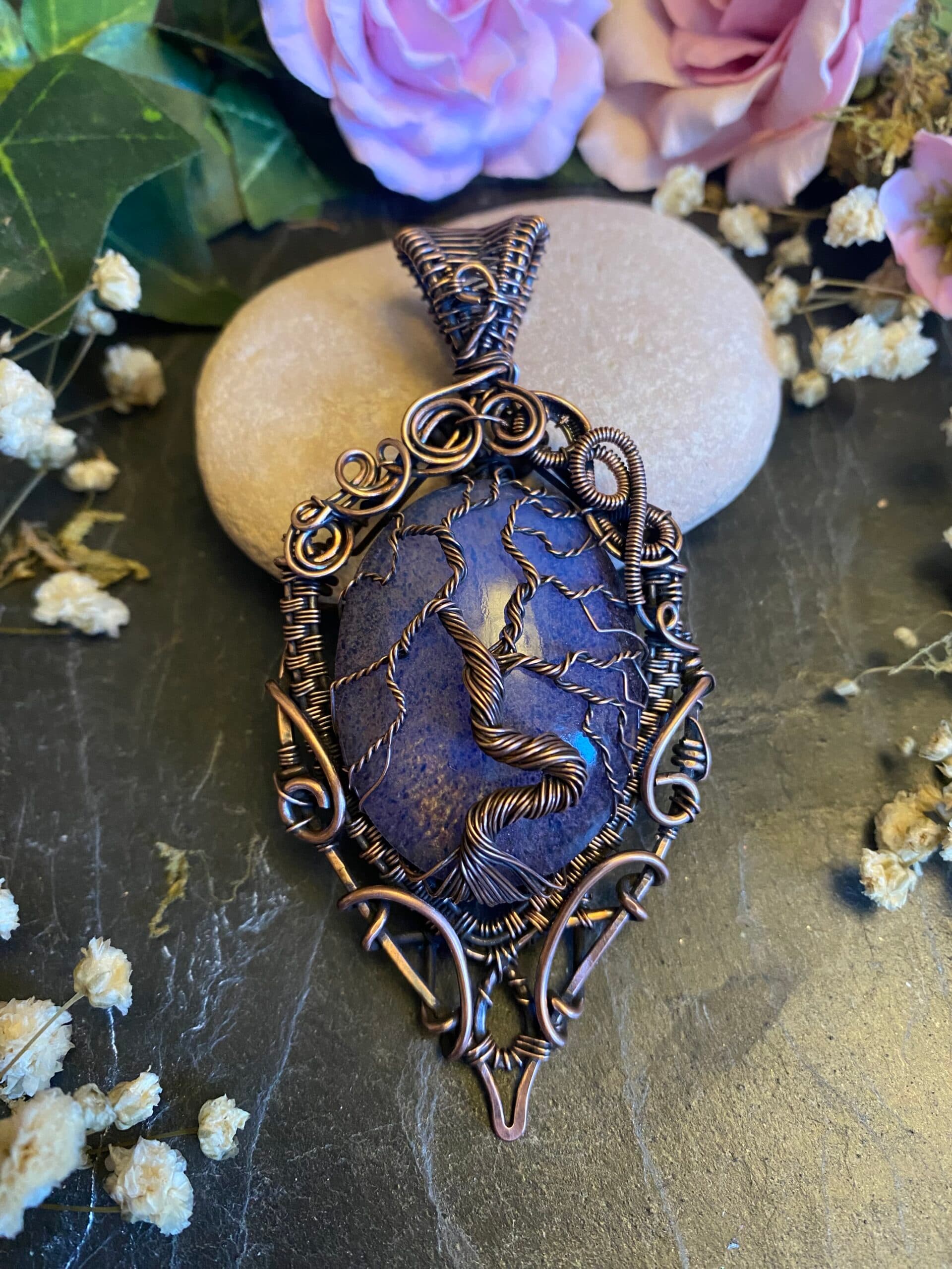 Handmade purple Tree of Life pendant featuring vintage Preciosa glass, intricate copper wire branches, roots and decorative scrollwork, displayed on dark slate.