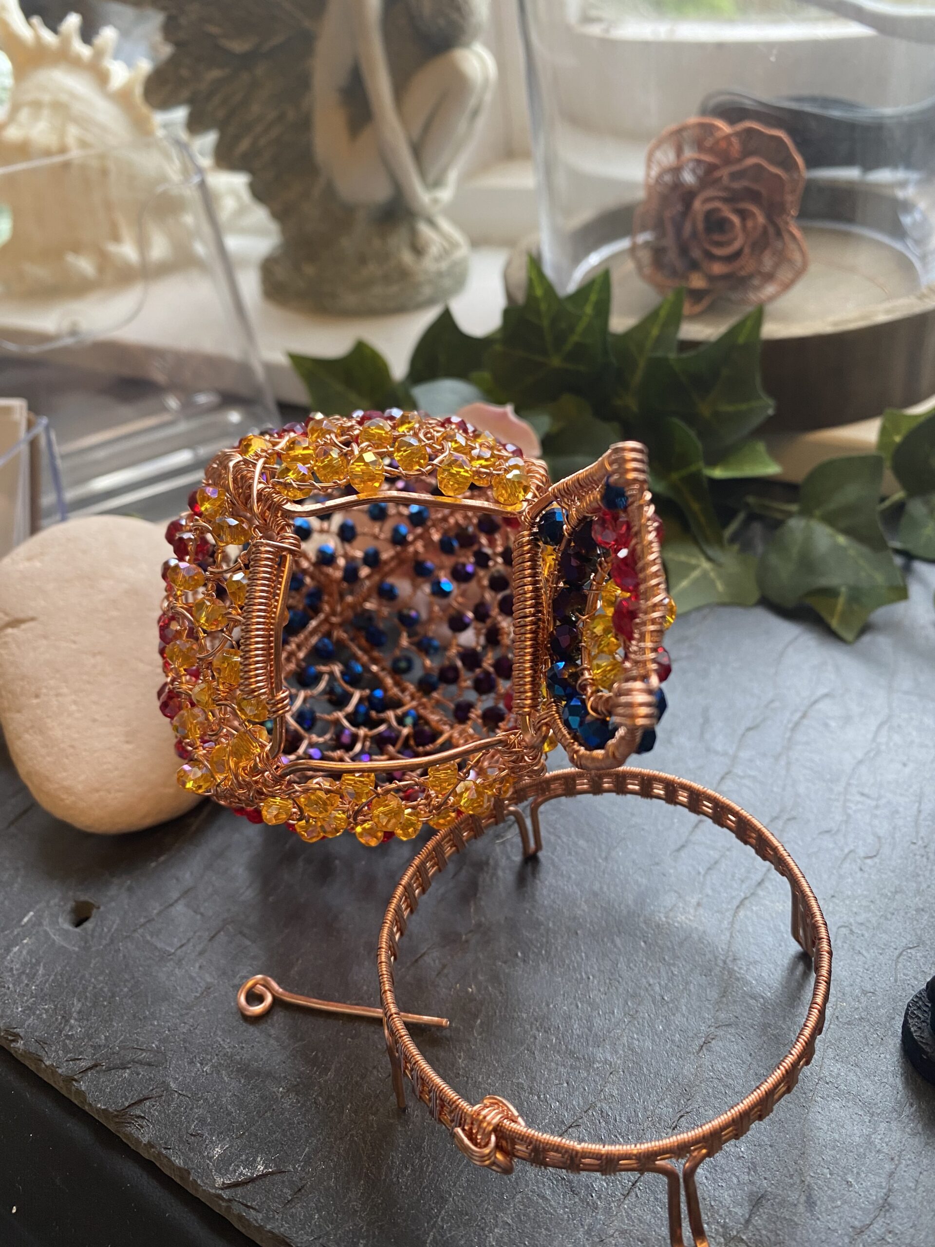 Hand-woven wire dragon’s egg with flame gradient beads, hinged decorative sculpture on cradle