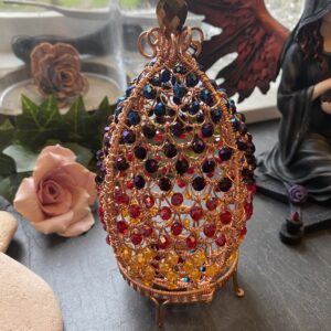 Hand-woven wire dragon’s egg with flame gradient beads, hinged decorative sculpture on cradle