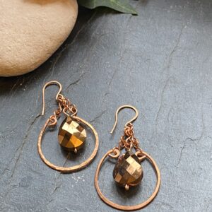 Handmade copper dangle earrings with hammered loop components and a teardrop shaped copper metallic glass bead.